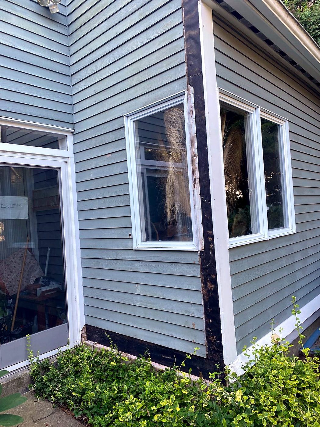 Deteriorated corner board and peeling window trim at a Concord, MA condominium before repair