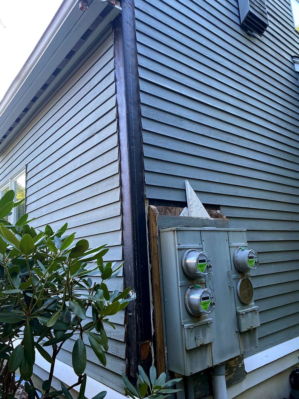 Corner board removed and wall opened beside the electric meter bank at a Concord, MA condominium