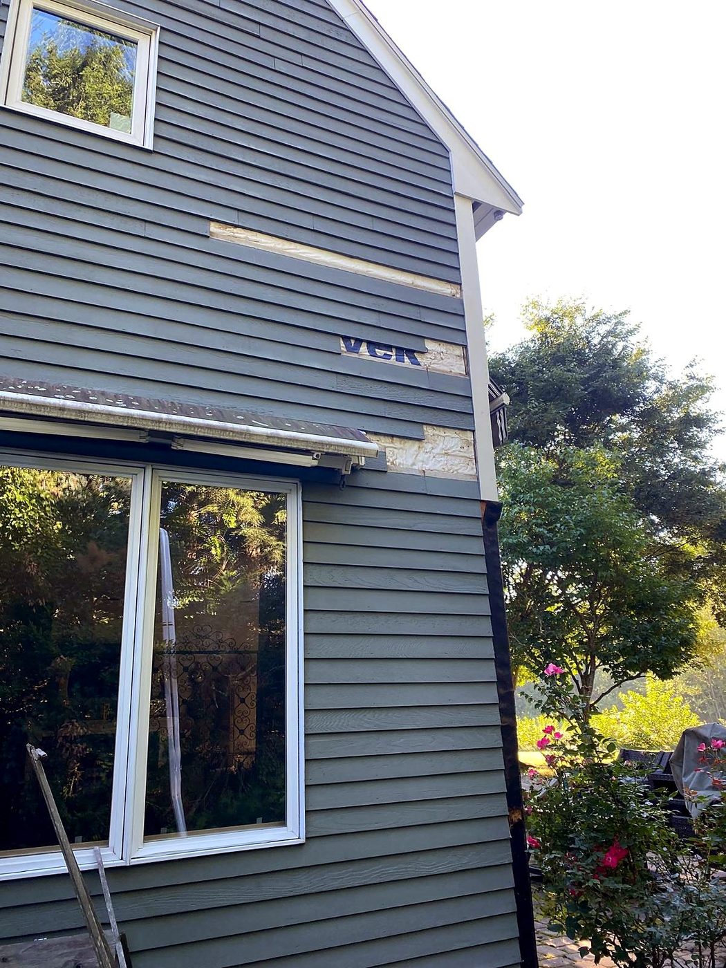 New siding boards patched into the gable wall during siding repair at a Concord, MA condominium