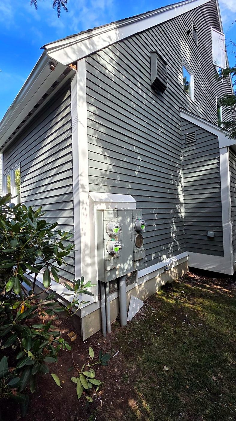 Finished white trim around the corner and electric meter bank at a Concord, MA condominium