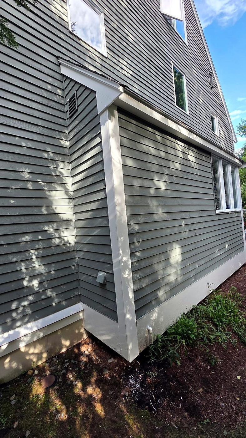 New white corner and base trim on lap siding at a Concord, MA condominium after repair