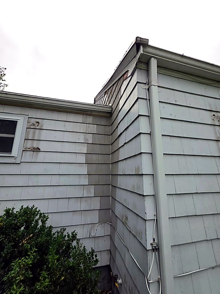Inside corner of the siding on a Worcester, MA cape before rot repair, with split and stained shingles