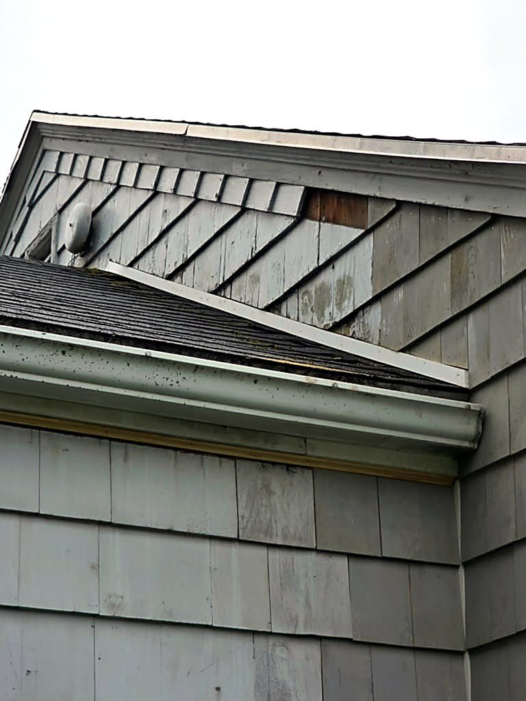 Worn and missing gable shingles on a Worcester, MA cape before siding repair