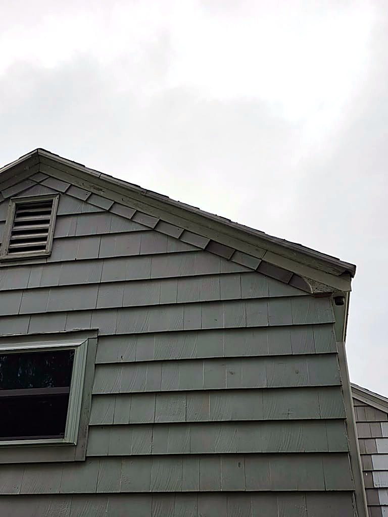 Gable end siding condition on a Worcester, MA cape before repair