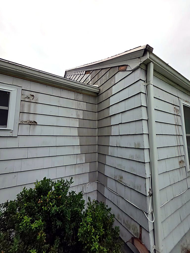 Stained siding along the inside corner and eave line of a Worcester, MA cape before rot repair