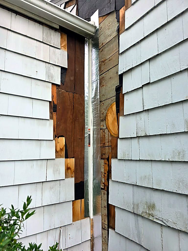 Siding removed at the inside corner of a Worcester, MA cape, exposing the sheathing during rot repair