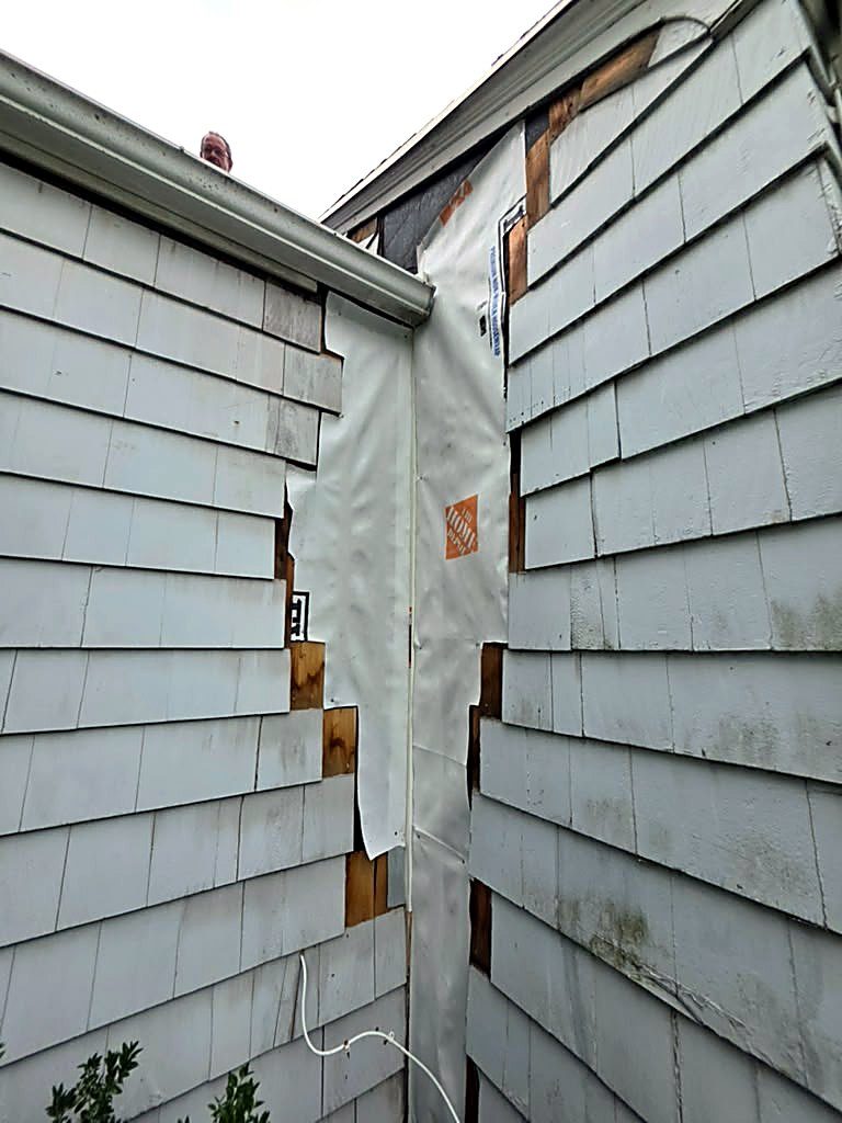 New weather barrier installed over the repaired corner of a Worcester, MA cape during siding repair