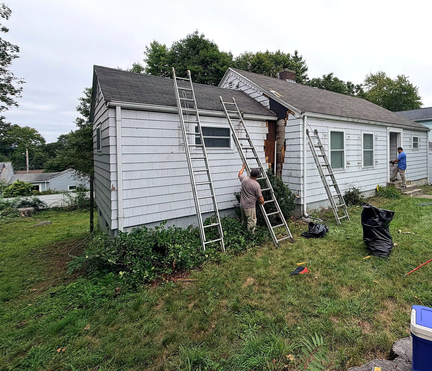 Maverick City Builders team on site with ladders during siding and rot repair on a Worcester, MA cape